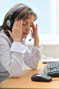 Tired woman in pain sitting at her computer - suffering from sleep problem and myalgia?.