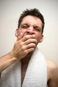 Yawning man with towel around his neck - he could do with Relax-the-Mind sleep therapy!