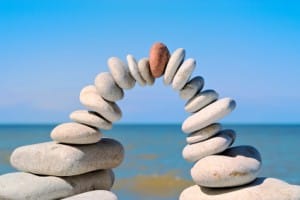 Inspirational stone arch with red stone at top in the morning on a beach