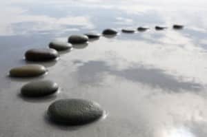 An alignment of flat rocks in water - stepping stones away from abuse